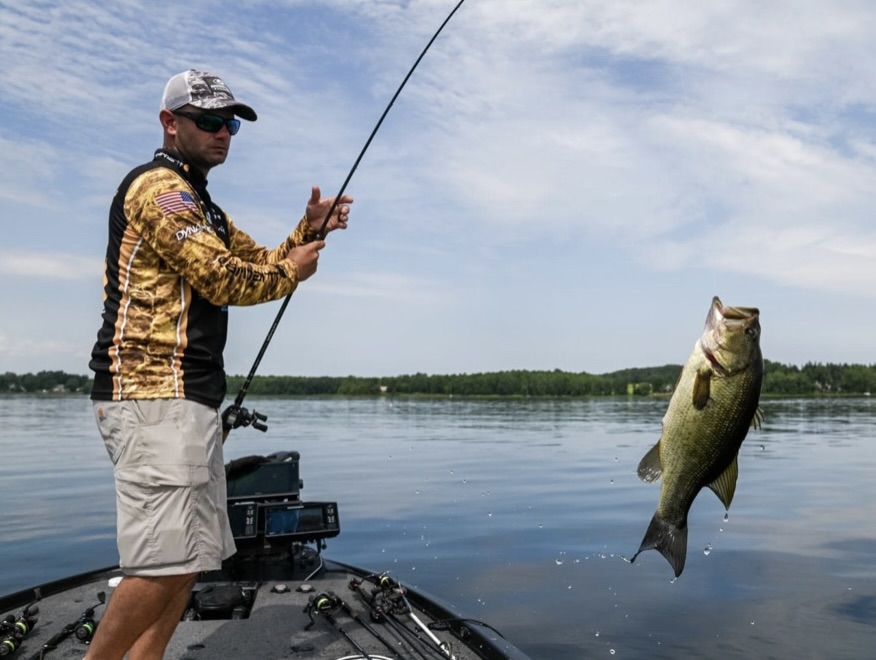 pro fisherman grabbing a bass on lake Champlain